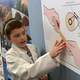 Ilustración para el artículo titulado Una niña inventa el dispensador de tiritas perfecto mientras superaba un cáncer en el hospital